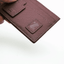 Porte-cartes en cuir marron avec une étiquette cousu en tons sur tons sur la face avant.